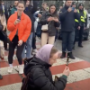 Orthodox woman prays while holding a cross as Ukrainian nationalists mock her